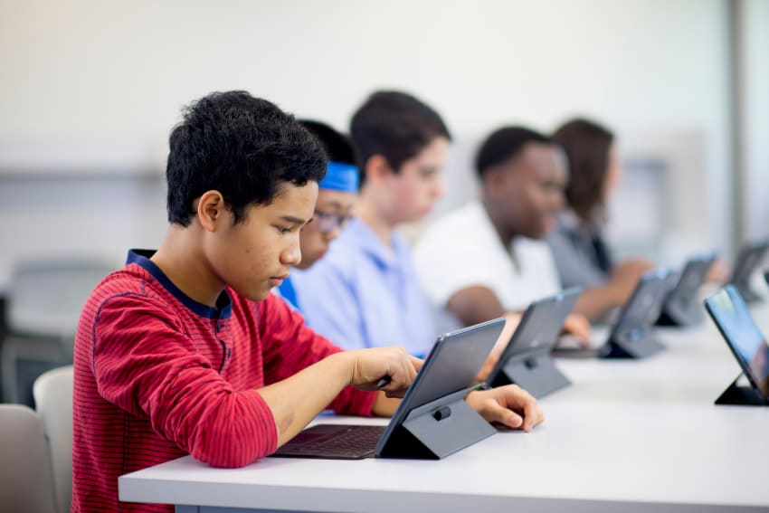 Crianças usando tela interativa em ambiente educacional